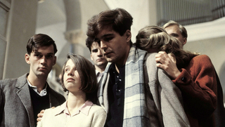 Szenenbild aus dem Drama &quot;Die weiße Rose&quot; (1982): Eine junge Frau und ein junger Mann gehen eine Treppe herunter. Hinter ihnen sind vier Männer zu sehen. (© picture alliance/United Archives/kpa)
