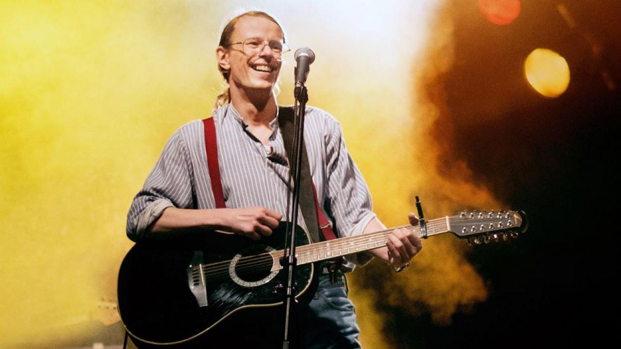 Gerhard Gundermann (Alexander Scheer) bei einem Konzert auf der Bühne mit Gitarre