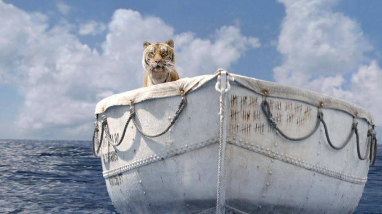 Ein Tiger sitzt allein in einem weißen Rettungsboot auf offenem Meer unter bewölktem Himmel.