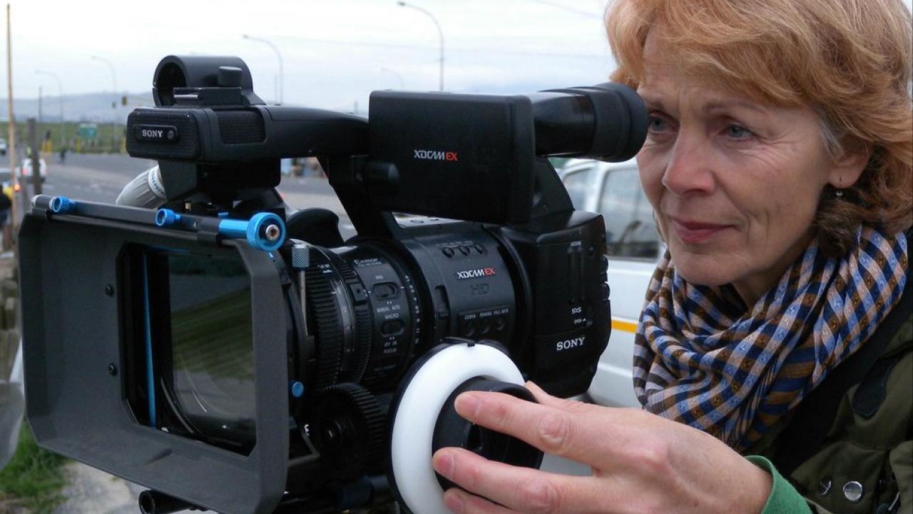 Regisseurin Sigrid Klausmann steht hinter einer großen Filmkamera.