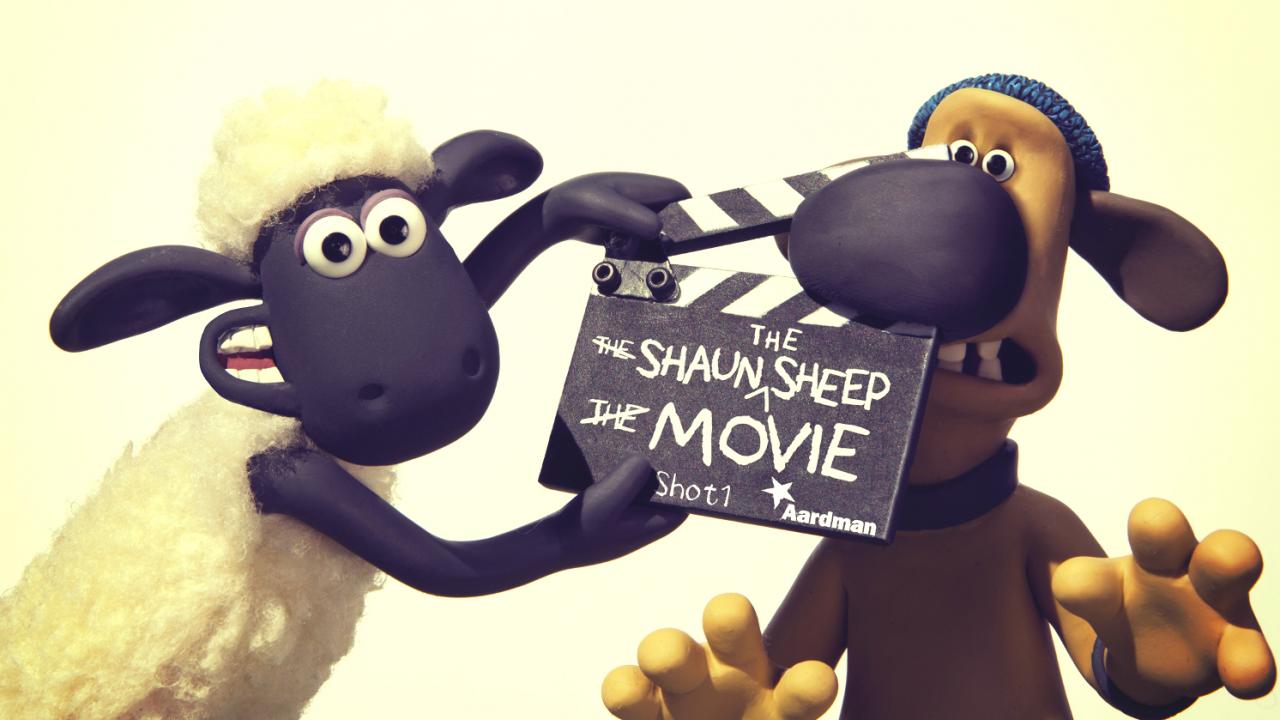 Die Knetfigur Shaun, das Schaf hält eine Filmklappe und klemmt damit die Nase einer Hundefigur ein.