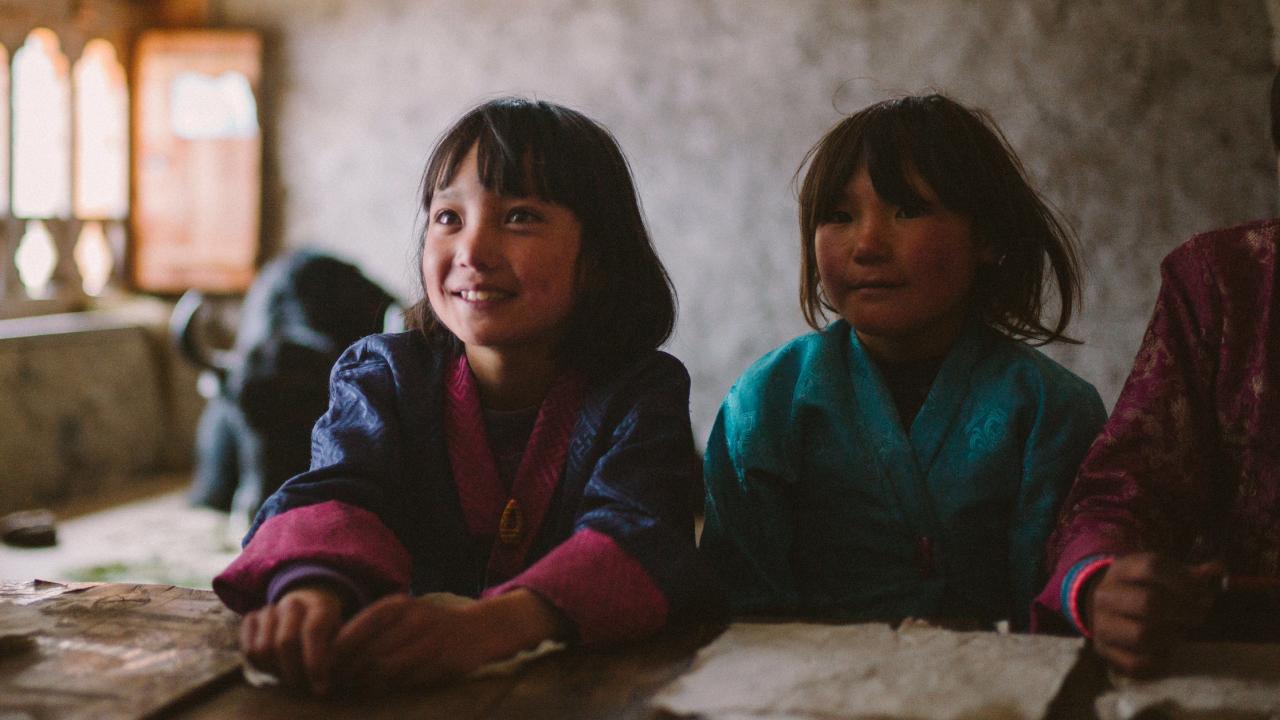 Lunana – Das Glück liegt im Himalaya, Szenenbild: Naufnahme von zwei Schulmädchen, die in an einem Schultisch sitzen