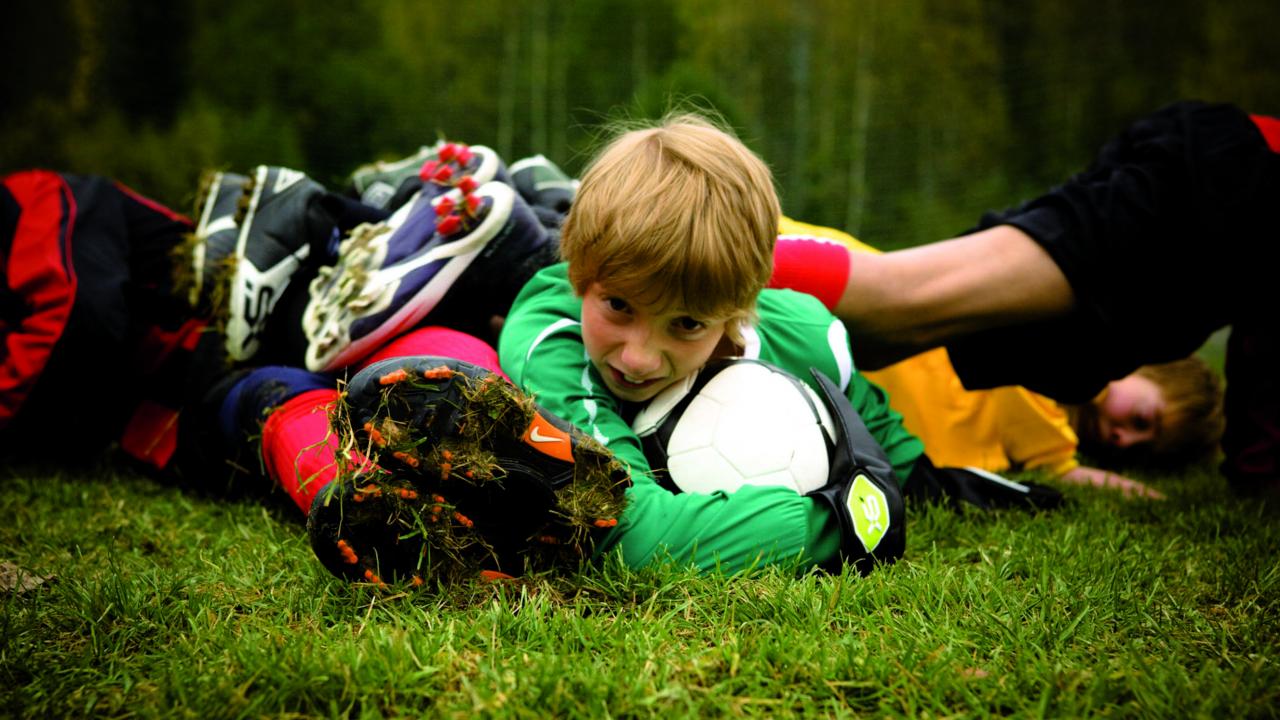 The Liverpool Goalie, Szenenbild: Nahaufnahme eines Jungen, der am Boden liegt und einen Fußball in den Händen hält