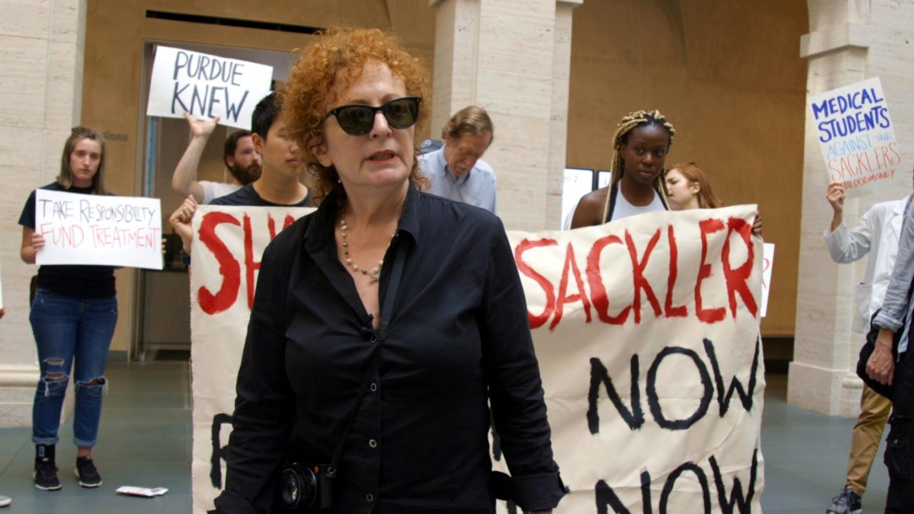 All the Beauty and the Bloodshed, Szenenbild: Porträt der Fotografin Nan Goldin während einer Protestaktion von P.A.I.N.