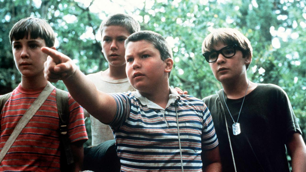 Stand by Me – Das Geheimnis eines Sommers, Szenenbild, Nahaufnahme: Vier etwa 12-jährige Jungen stehen dicht nebeneinander in einem Wald. Einer zeigt mit seinem Film auf etwas, das außerhalb des Bildes liegt.