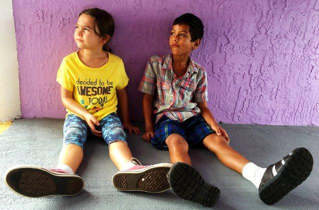 The Florida Project (Szenenbild: Moonee und ihr Freund sitzen auf dem Boden. Die Hauswand ist  violett.)