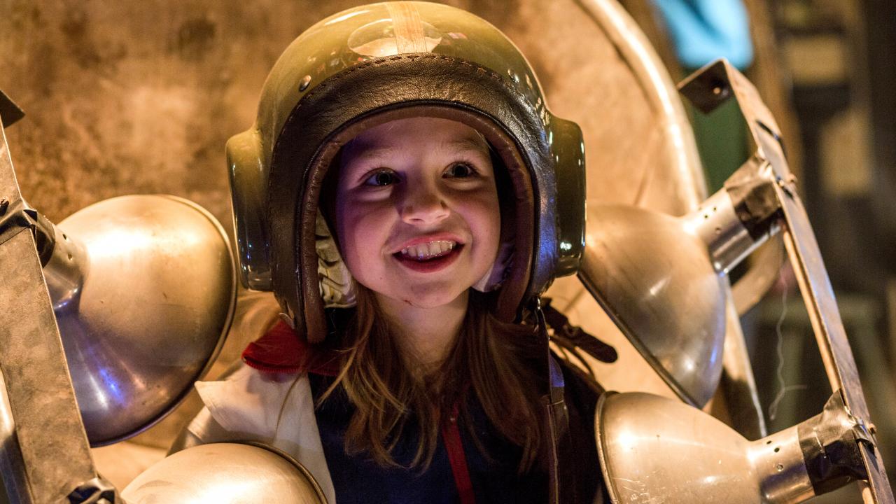 Szenenbild aus dem Kinderfilm "Sputnik": Ein Mädchen trägt einen selbst gemachten, goldenen Helm und lächelt.