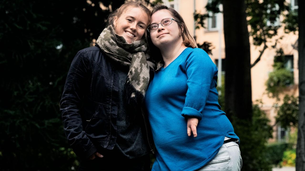 Die ehemaligen Klassenkameradinnen Luca und Natalie stehen lächelnd nebeneinander.