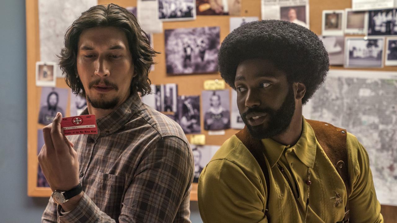 Szenenbild aus dem Film BLACKKKLANSMAN: Der weiße Polizist Flip und sein afroamerikanischer Kollege Ron betrachten einen Mitgliedsausweis des Klu Klux Klans.