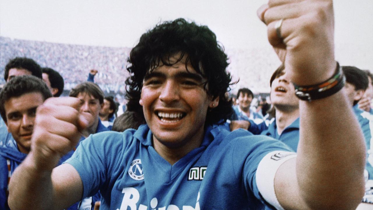 Ein jubelnder Diego Maradona läuft im Stadion mit erhobener Fäusten