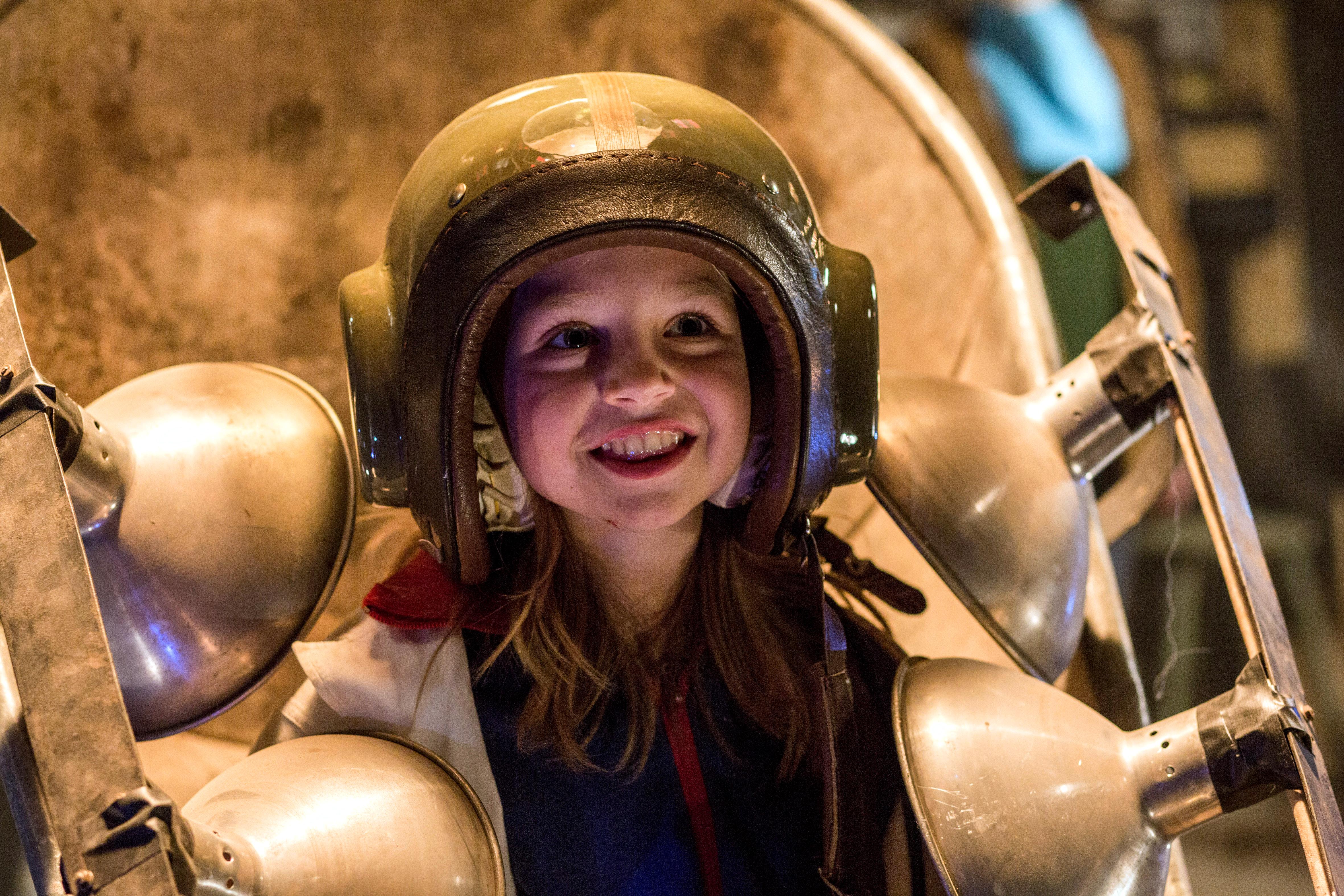 Szenenbild aus dem Kinderfilm "Sputnik": Ein Mädchen trägt einen selbst gemachten, goldenen Helm und lächelt.