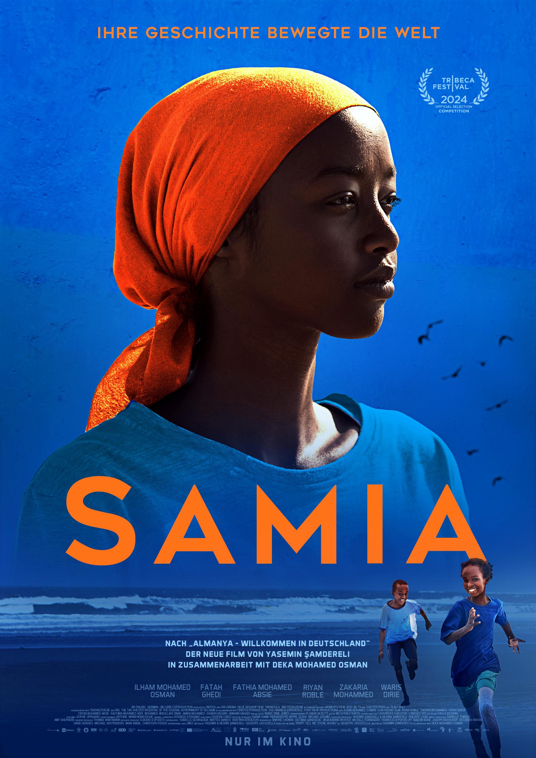 Filmplakat zum Drama SAMIA: Vor leuchtend blauen Hintergrund ist eine junge Schwarze Frau zu sehen. Sie trägt ein blaues Shirt und ein orangefarbenes Kopftuch. Auf ihrer Brust steht in orangefarbenen Lettern der Filmtitel