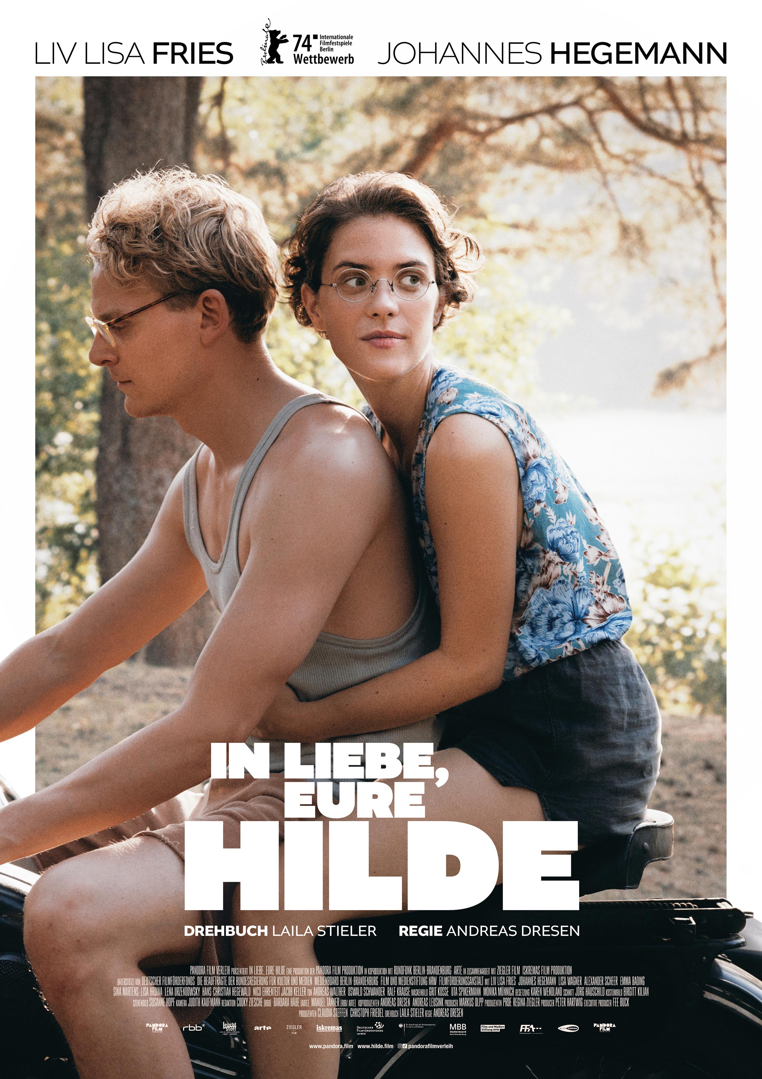 Filmplakat zum Drama IN LIEBE, EURE HILDE: Ein junger Mann (im Film: Hans Coppi) und eine junge Frau (im Film: Hilde Coppi) fahren auf einem Motorrad durch eine Waldgegend. Sie hält auf dem Rücksitz ihre Hände um ihn geschlungen. Die beiden sind leichtbekleidet, die Sonne scheint, im Hintergrund ist ein See zu sehen.