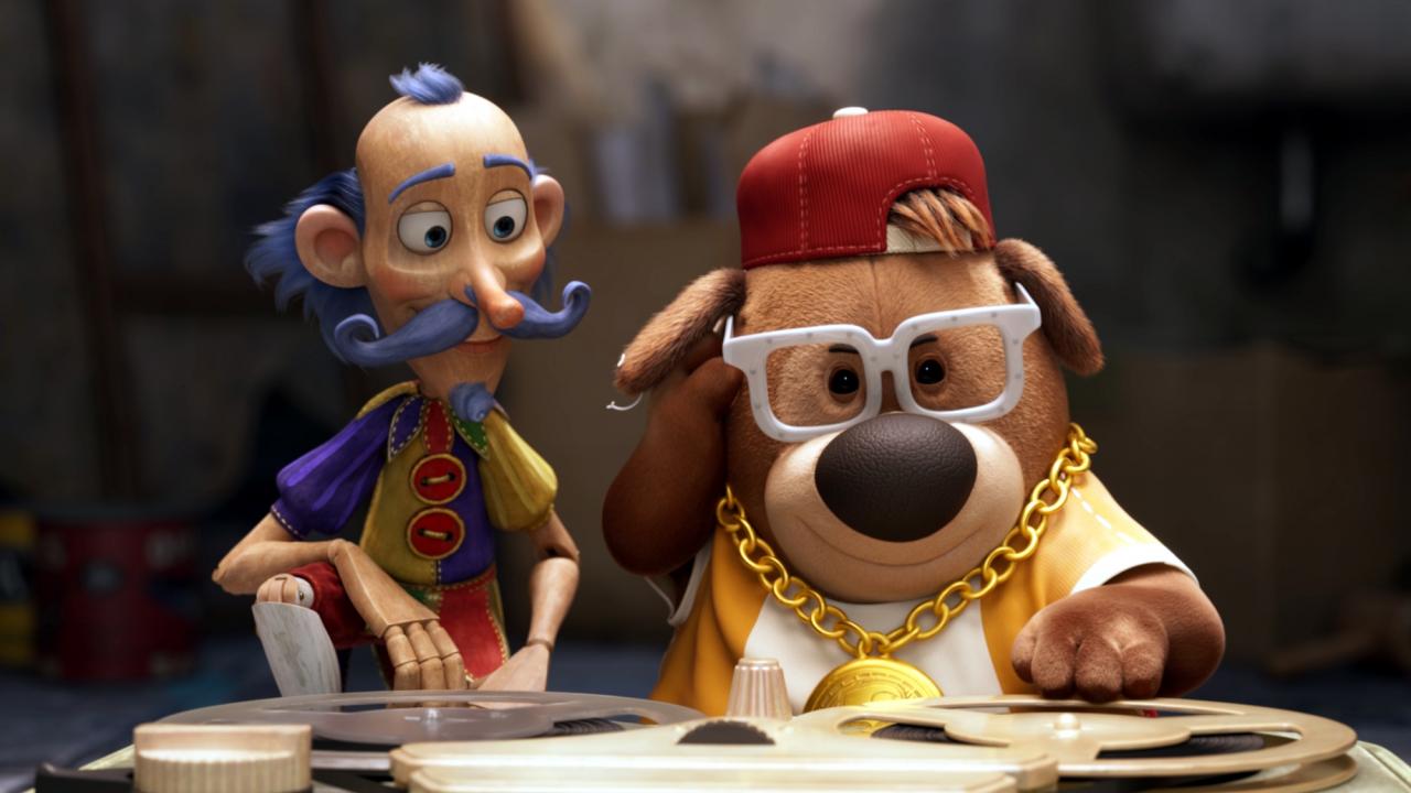 Szenenbild aus dem Animationsfilm DIE UNZERTRENNLICHEN – ZWEI DURCH DICK UND DÜNN: Eine Holzfigur, die aussieht wie Don Quijote, und ein Stofftierhund, der wie ein Rapper gekleidet ist, sitzen vor einem alten Tonbandgerät.