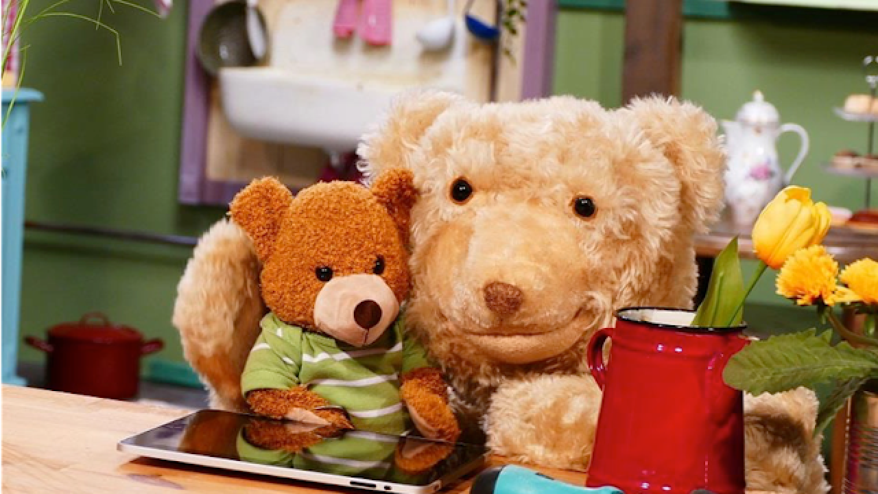 Knopf & Knöpchen, Szenenbild: Ein großer und ein kleiner Teddybär sitzen an einem Küchentisch.