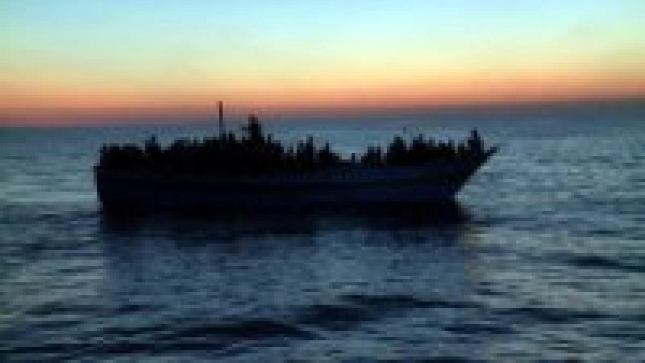 Eldorado, Szenenbild: Ein Flüchtlingsboot auf dem Meer im Sonnenunterngang als Silhouette