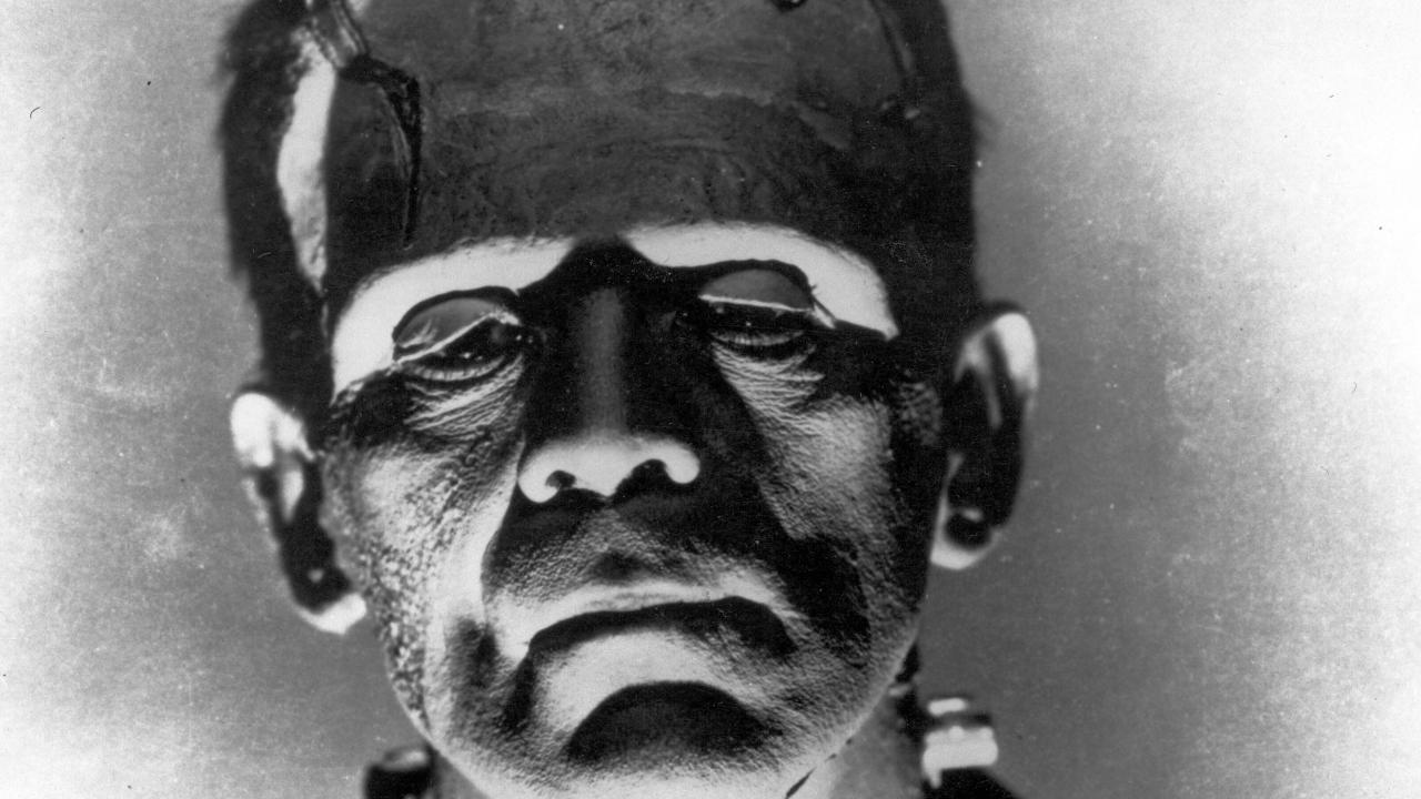 Frankenstein, Szenenbild: schwarz-weiße Nahaufnahme eines Mannes mit Narben im Gesicht und Schrauben am Hals