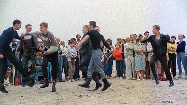 flüstern & SCHREIEN, Szenenbild: Jugendliche tanzen am Strand Pogo, Erwachsene, Kinder und Jugendliche schauen zu.