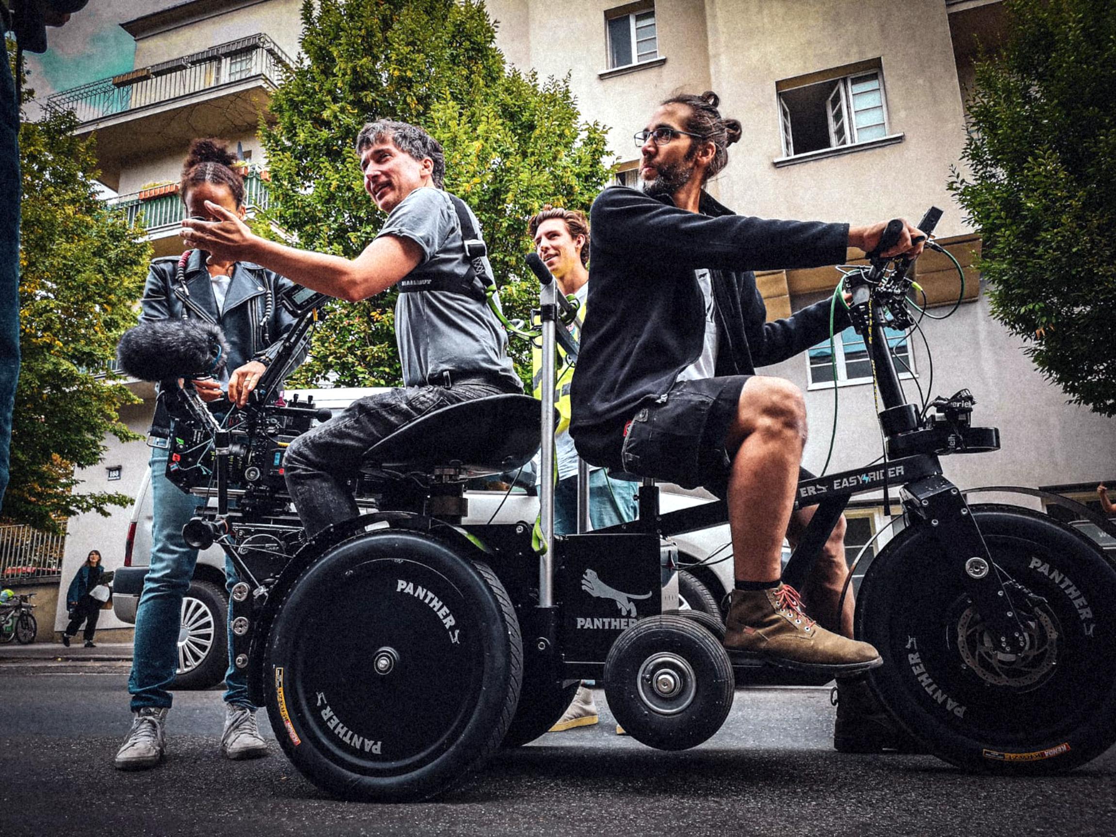 Setfoto vom Dreh zu Neue Geschichten vom Franz: Der Kameramann sitzt mit seiner Kamera auf einem sogenannten Easy Rider, der wie ein großes Dreirad aussieht.