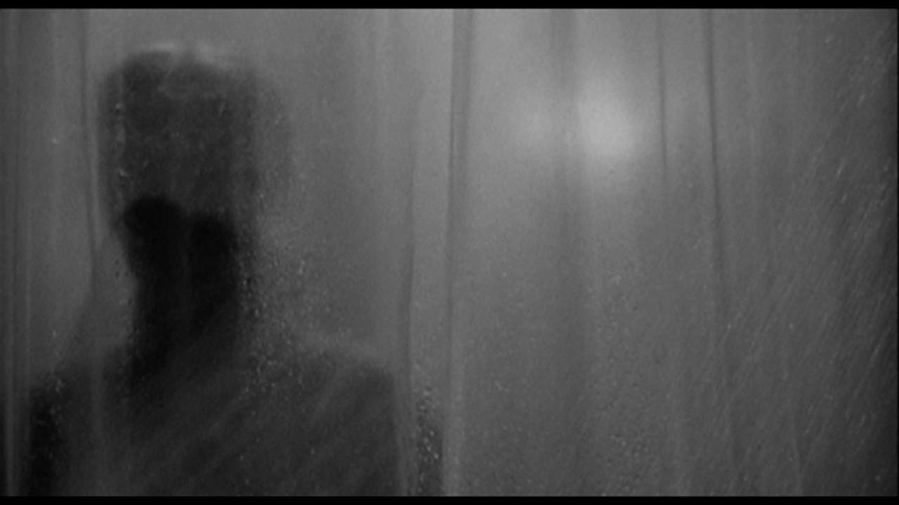 Screenshot aus dem Film "Psycho": In Nahaufnahme zeichnet sich hinter einem halbtransparenten Vorhang schemenhaft eine Person ab.